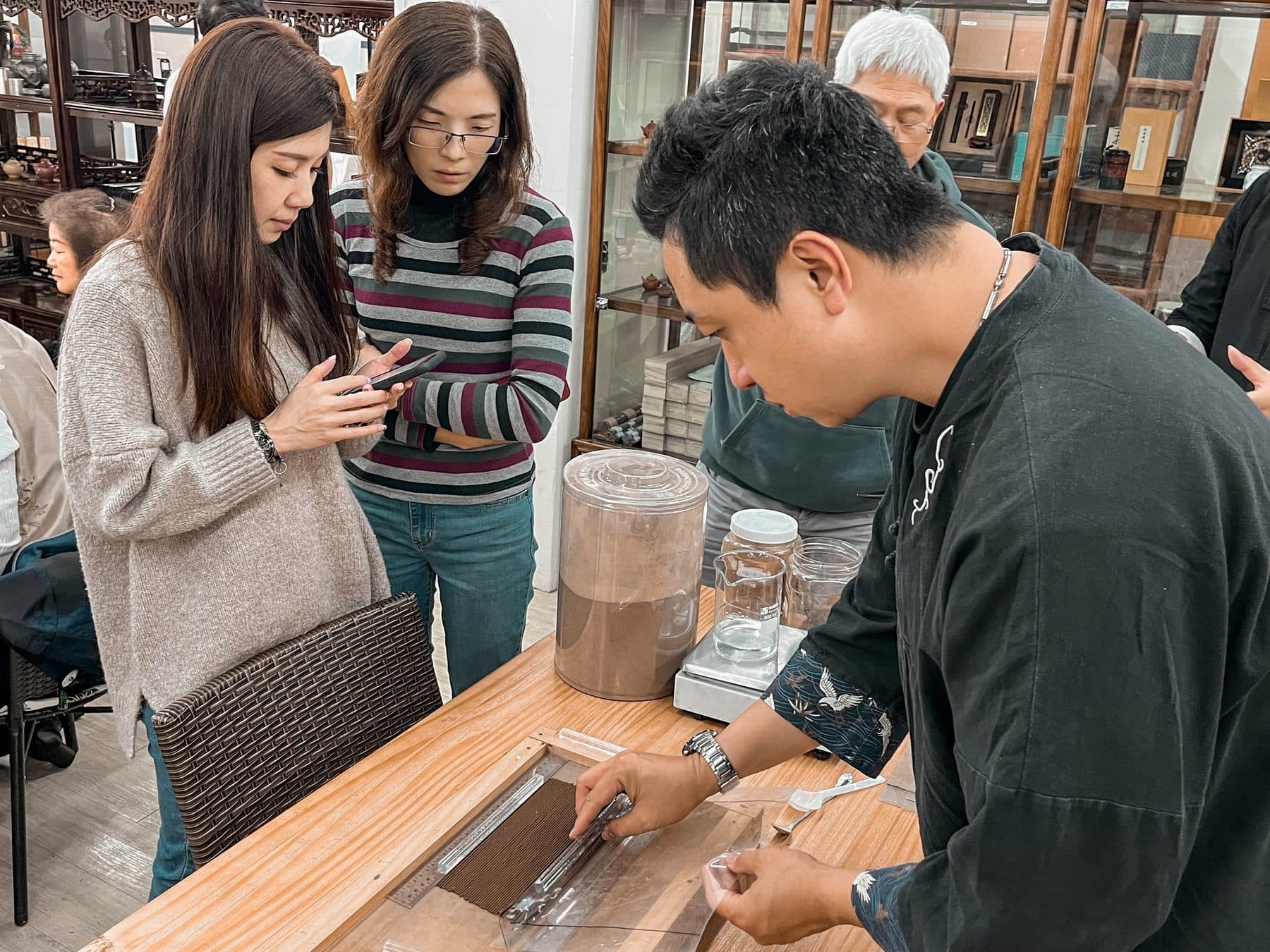 主持人示範品香，來賓圍在旁邊看
